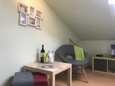 a room with a chair and a table with a bottle of wine at The Backpacker's Spot - Bus & Railway Station Gem by Flat Mаnager in Sofia