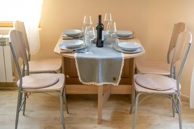 a dining room table with two chairs and a table with wine bottles at Design Loft in the City Center in Sofia