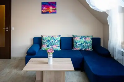 a blue couch in a living room with a table at Design Loft in the City Center in Sofia
