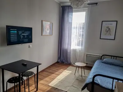 a living room with a bed and a table and a window at Cozy Apartment in Sofia Center in Sofia