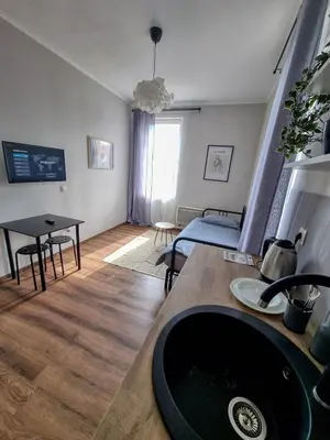 a bathroom with a sink and a living room at Cozy Apartment in Sofia Center in Sofia