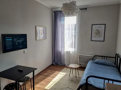 a bedroom with a bed and a table and a window at Cozy Apartment in Sofia Center in Sofia