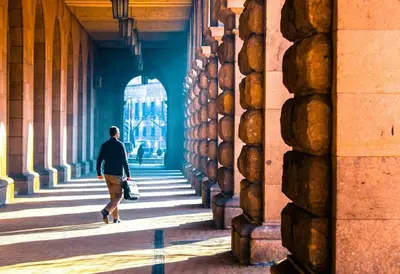 a man walking down a hallway in a building at Cozy 2-Bedroom Flat in the very Center of Sofia in Sofia