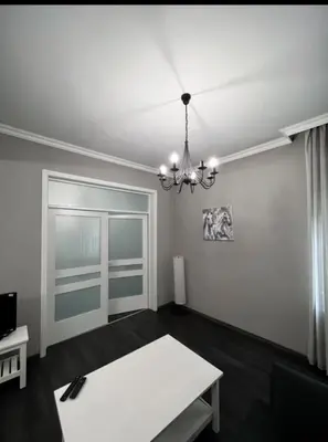 a living room with a table and a chandelier at Doctors Garden Appartment in Sofia