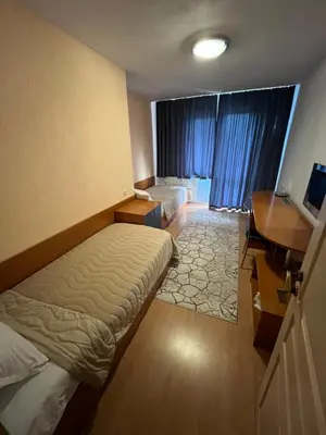 a hotel room with a bed and a desk and a desk at Хотел ПАНОРАМА ДОСПАТ in Dospat