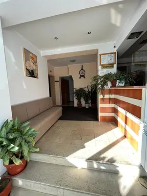 a living room with a couch and potted plants at Хотел ПАНОРАМА ДОСПАТ in Dospat