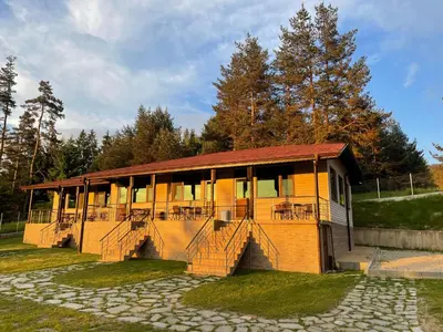 a building with tables and chairs in front of it at Villa Siesta Dospat in Dospat
