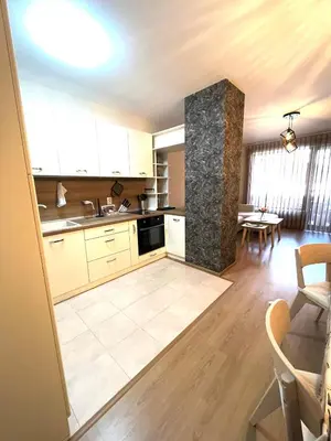 a kitchen with white cabinets and a table at Апартамент Ренета Apartment Reneta in Velingrad