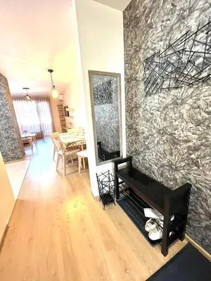 a living room with a piano and a stone wall at Апартамент Ренета Apartment Reneta in Velingrad