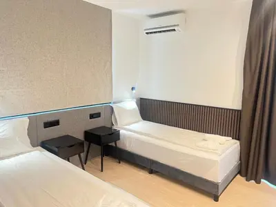 a small room with two beds and a table at SPA Apartments Perun in Sandanski