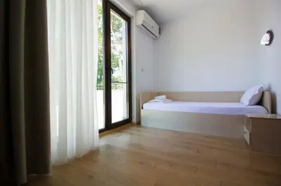 a white room with a bed and a window at SPA Apartments Perun in Sandanski