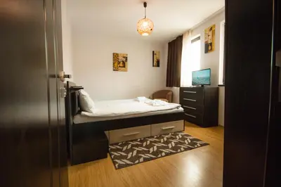 a small bedroom with a bed and a dresser at SPA Apartments Perun in Sandanski