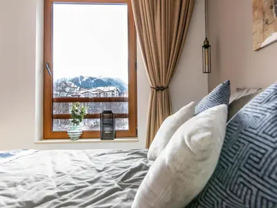 a bed with pillows and a window with a view at Modern Mountain Getaway in Bansko