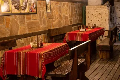 two tables in a restaurant with red table cloth at Safari Village Velingrad in Velingrad