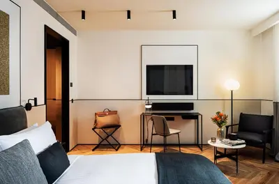 a hotel room with a bed and a desk with a television at Juno Hotel Sofia, a Member of Design Hotels in Sofia