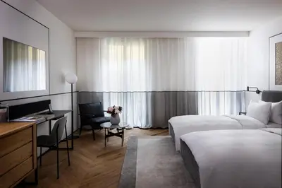a hotel room with two beds and a desk at Juno Hotel Sofia, a Member of Design Hotels in Sofia