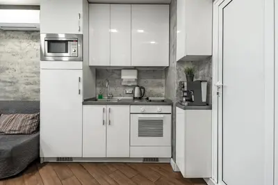 a kitchen with white cabinets and a refrigerator at Luxury Studio Silver by Flat Mаnager in Sofia