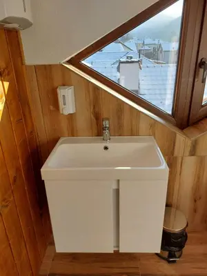 a white sink in a bathroom with a window at Къща за гости Бялото Конче in Beli Iskar