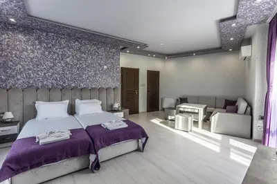 a bedroom with a bed with a purple bedspread at Никонел in Oborishte
