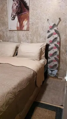 a bedroom with a bed and a horse painting on the wall at APARTAMENT-DAMO in Pamporovo