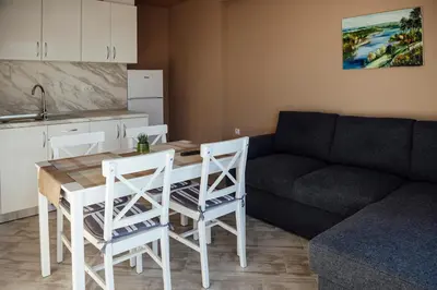 a living room with a table and chairs and a couch at Къща за гости Давиос in Sapareva Banya