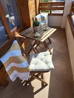 a wooden table and chairs on a balcony with a table at Cozy studio with balcony and incl SPA in 4-star hotel Saint Ivan Rilski , Bansko in Bansko