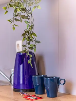 a purple vase and three blue cups on a table at Vitosha Viewpoint - Chic City Studio in Sofia