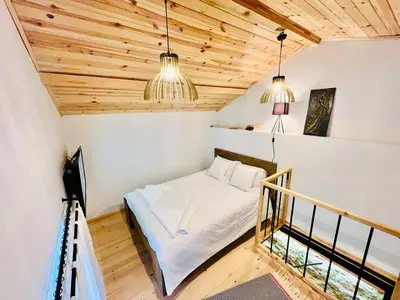 a bedroom with a bed in a room with wooden ceilings at Balloon Boutique House, City Centre in Plovdiv