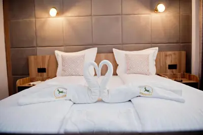 two towels in the shape of hearts are on a bed at СПА Хотел Романтика in Sarnitsa