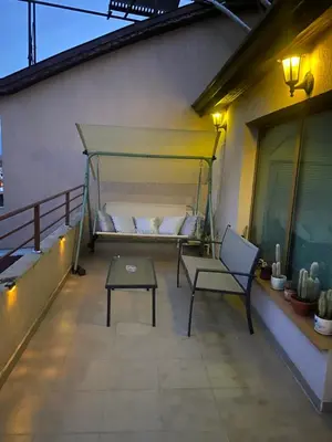 a bed on a balcony with a table and a bench at Мезонет “Djanina” in Sandanski