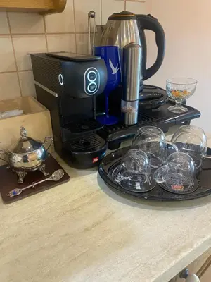 a counter top with a coffee maker and glasses at Мезонет “Djanina” in Sandanski