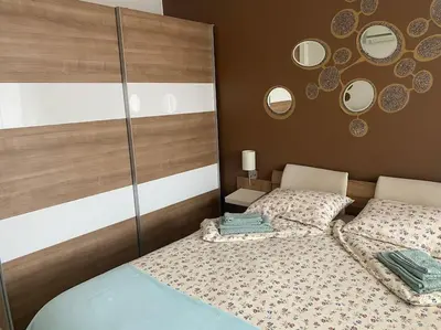 a bedroom with a bed and mirrors on the wall at Lovely 1-bedroom apartament with free parking in Sofia