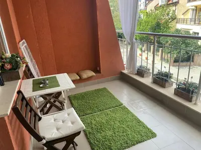 a balcony with a table and a green rug at Lovely 1-bedroom apartament with free parking in Sofia