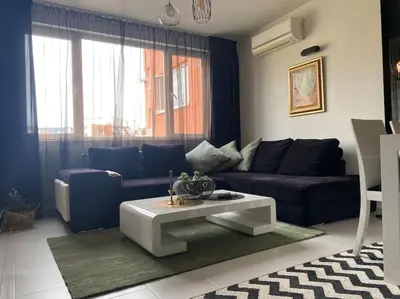 a living room with a blue couch and a table at Lovely 1-bedroom apartament with free parking in Sofia