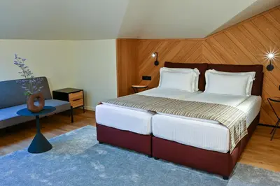 a bedroom with a large bed and a chair at Едно Време in Karlovo