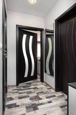 a hallway with black doors and a tile floor at Florance flat next to Old Town & City Center NEW in Plovdiv