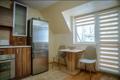 a kitchen with a small table and a refrigerator at Apart Centar in Plovdiv