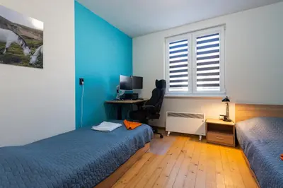 a bedroom with two beds and a desk and a window at DevIn Coworking & Coliving in Devin