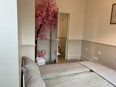 a bedroom with a bed and a mirror and flowers at Vitosha 60 in Sofia