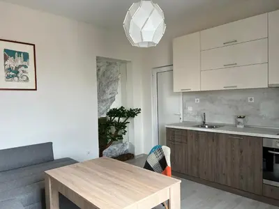 a kitchen with white cabinets and a wooden table at Vitosha 60 in Sofia