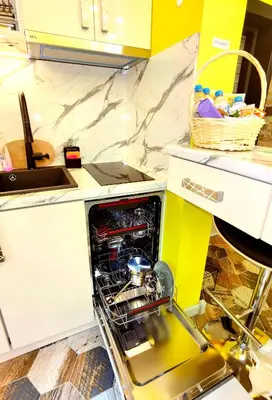 an open dishwasher in the middle of a kitchen at Sofiel cozy apartment - Top Center Sofia in Sofia
