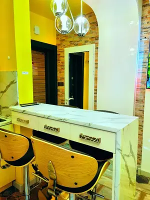 a kitchen with yellow walls and a counter with two chairs at Sofiel cozy apartment - Top Center Sofia in Sofia