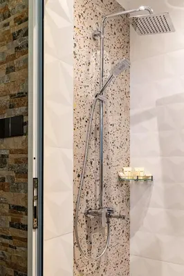 a shower in a bathroom with a tile wall at Sofiel cozy apartment - Top Center Sofia in Sofia