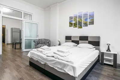 a bedroom with a large bed and a chair at 2BD Citrus Apartment, Aristocratic Sofia Living by Flat Mаnager in Sofia