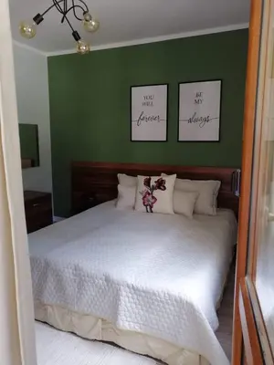 a bedroom with a white bed with green walls at Утро без Аларма, Смолянски езера. Alarm free Morning Smolyan lakes in Smolyan