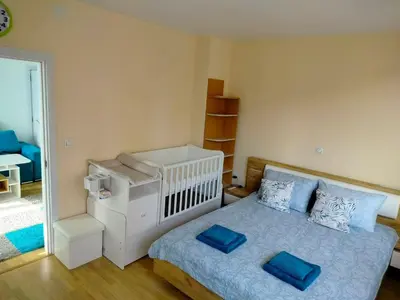 a bedroom with a bed with blue pillows on it at Alinik Apartment in Sofia