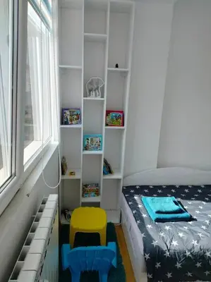 a small bedroom with a bed and a yellow chair at Alinik Apartment in Sofia