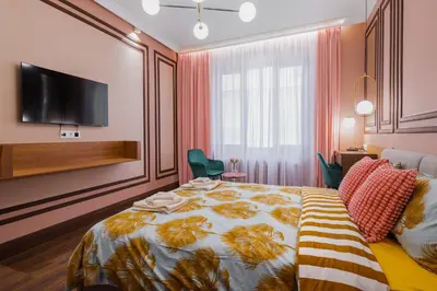 a bedroom with a bed and a tv on a wall at Charming Pastel 1BD Flat in The Heart of Sofia by Flat Mаnager in Sofia