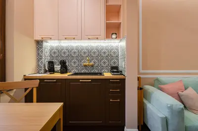 a kitchen with a stove top oven next to a couch at Charming Pastel 1BD Flat in The Heart of Sofia by Flat Mаnager in Sofia