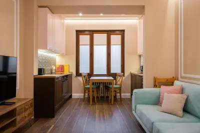 a living room with a blue couch and a kitchen at Charming Pastel 1BD Flat in The Heart of Sofia by Flat Mаnager in Sofia